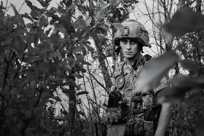 Ein junger Soldat hält eine Waffe.