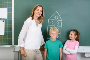 Lehrerin und Kinder rechnen an der Tafel