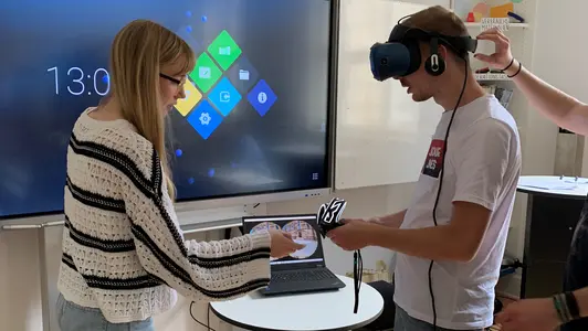 Eine junge Frau und ein Junger Mann testen eine VR-Brille.