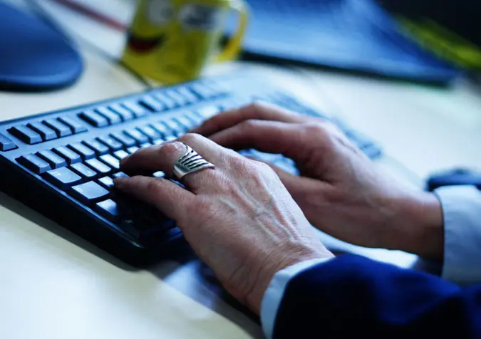 Hände tippen auf Computertastatur