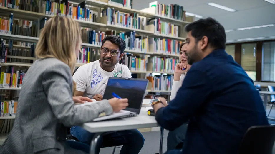 Bibliothek Ein Teil der Gruppe bespricht sich in der Bibliothek