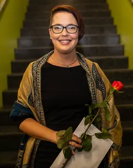 A photo of Dr. Mareike Spychala, a white woman with short hair and a sidecut. She is wearing glasses and a black dress.