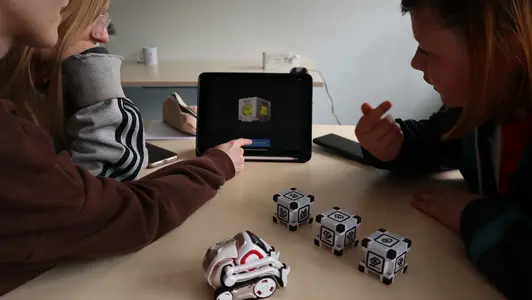 Mädchen bedienen einen Mini-Roboter