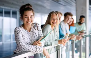 University students standing and looking at camera indoors, back to school concept.