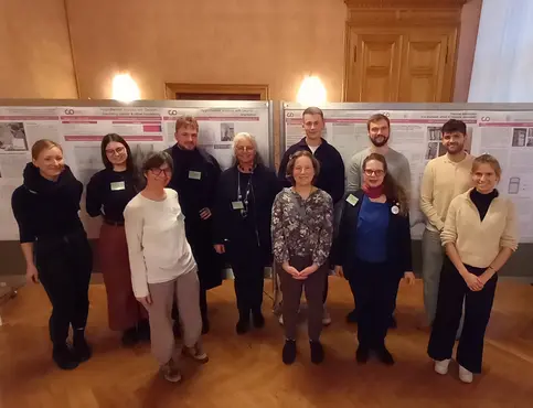 Studierende mit Prof. Troi und Prof. Hess auf der CHNT in Wien Menschen vor Plakaten in einem prunktvollen Raum