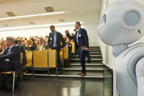 vollbesetzter Hörsaal und Roboter Pepper mit dabei