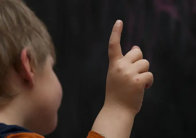 Kind meldet sich mit Fingerzeig
