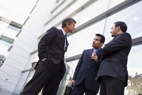 Group of businessmen talking outside office building