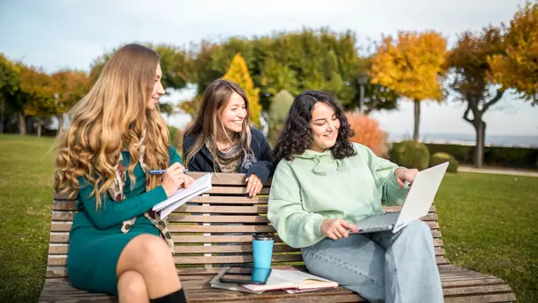 Studierende am Lernen auf einer Parkbank