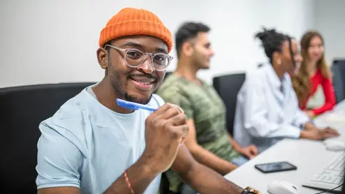 Studierende sitzen an den Computern im PC-Raum