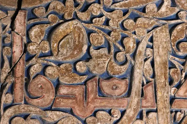 Detail of stucco panel at the Pir-i Bakran mausoleum (1298-1313) near Isfahan. The stucco panel contains a historic inscription dated 1303-04. Its relief contains traces of inscription and ornamentation gilding, red inscription outlines and colouring on blue background. (Photographer: Ana Marija Grbanovic)