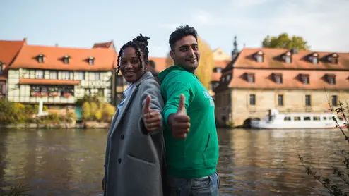 Students in Bamberg Studierende stehen bei Klein Venedig und geben Daumen nach oben