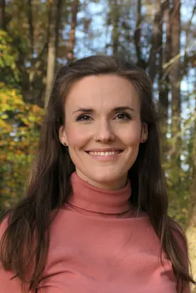 Person mit rosa Oberteil und braunen Haaren