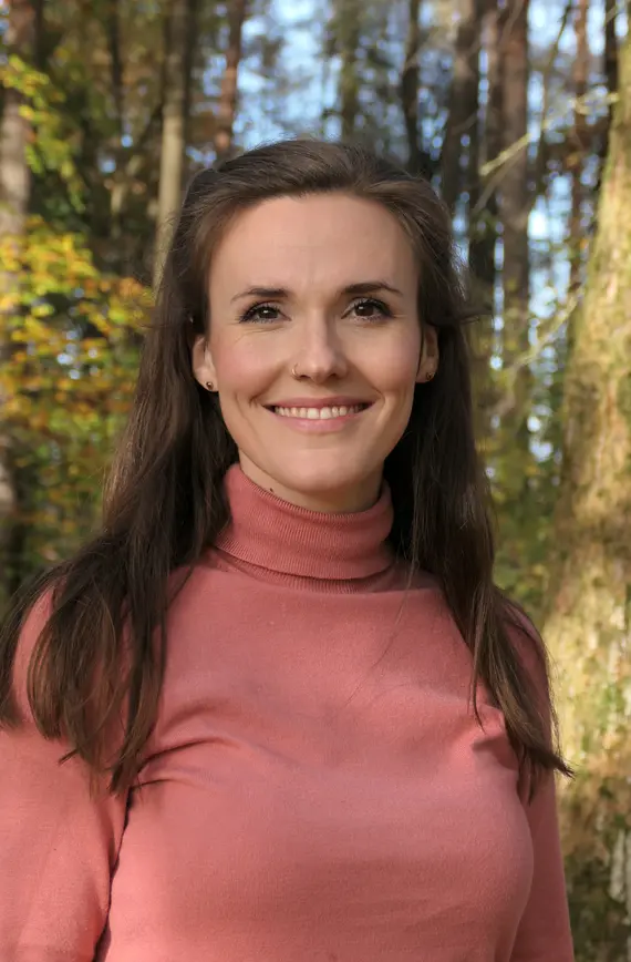 Person mit rosa Oberteil und braunen Haaren