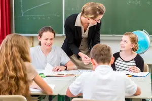 Schüler machen Gruppenarbeit mit Unterstützung durch eine Lehrerin