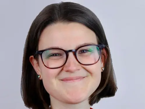 Portraitfoto Pia Seiler. Frau mit halblangen dunklen Haaren und Brille sowie roter Bluse lächelt sympathisch in die Kamera.