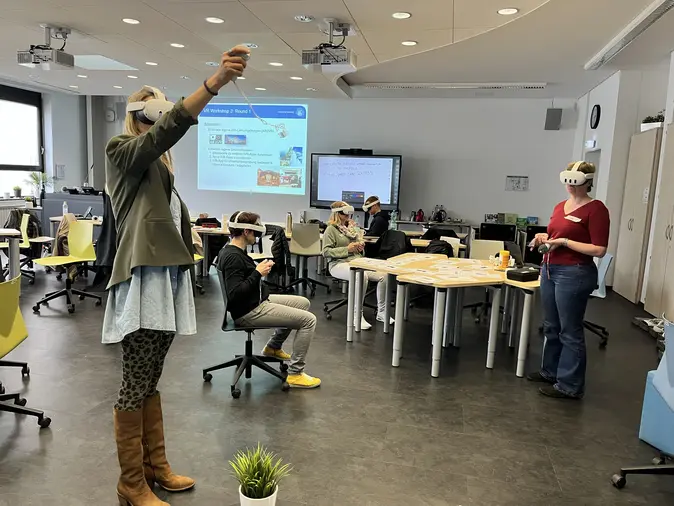 Menschen mit VR-Brillen in einem Seminarraum