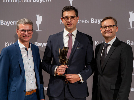 Bernd Sibler (l.) und Reimund Gotzel (r.) haben Christoph Weinert den Kulturpreis Bayern überreicht.