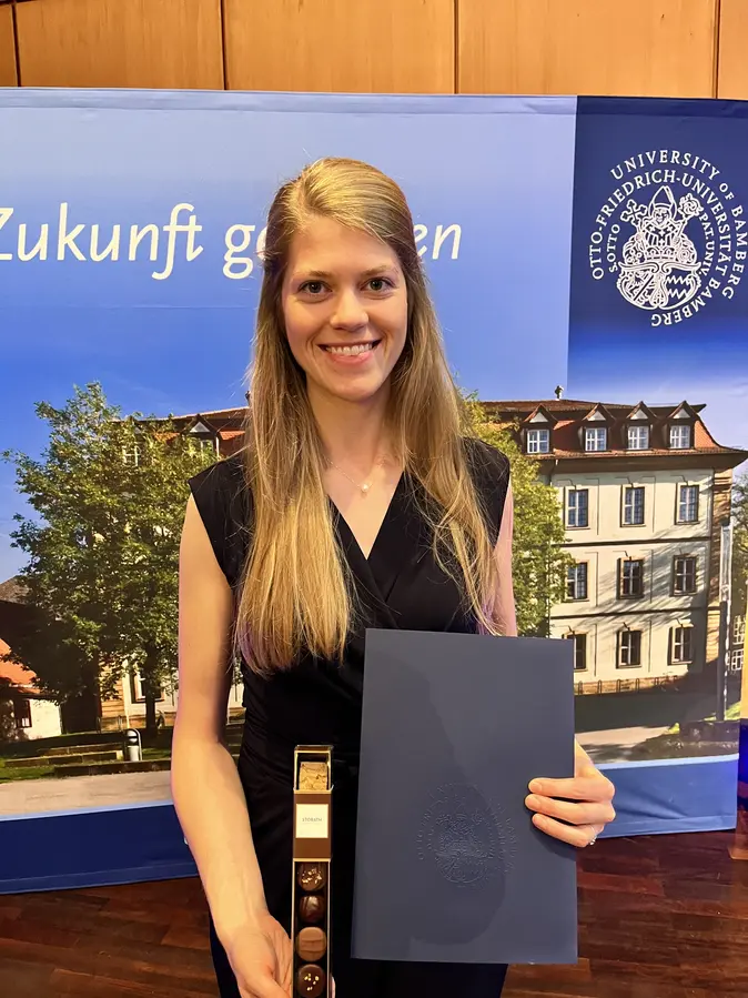 Wissenschaftliche Mitarbeiterin Jana Hock mit Urkunde zum Diversity-Preis.
