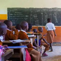 Children in uniforms in primary school classroom listetning to teacher in rural area near Arusha, Tanzania, Africa.