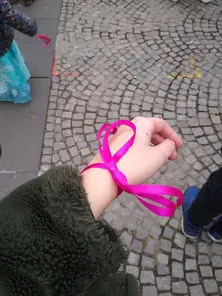 Hand einer Teilnehmerin mit einer rosa Schleife um das Handgelenk