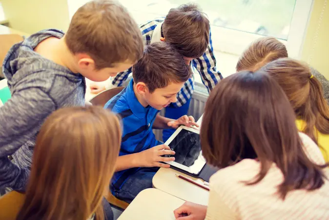 group of school kids with tablet pc in classroom