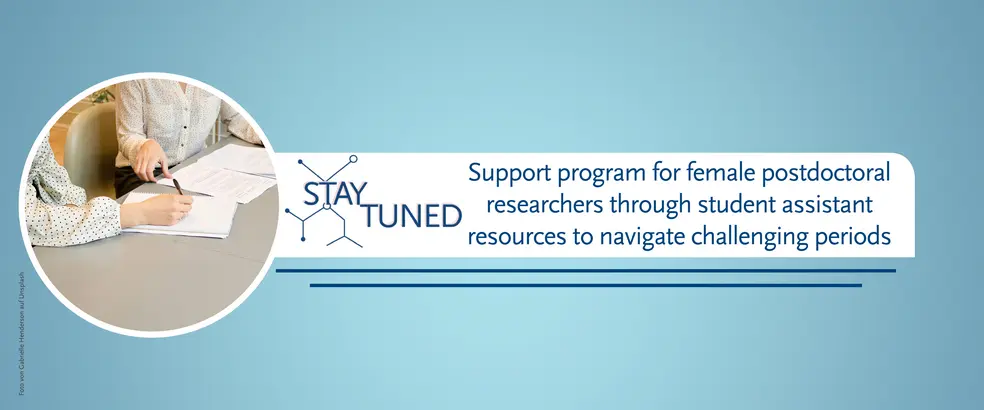 This is a banner with a blue background for the page 'StayTuned - a support program for female postdoctoral researchers through student assistant resources to navigate challenging periods'. In a circular image, two women can be seen sitting, one of them holding a pen while papers lie on the table.