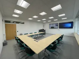 Das Bild zeigt den Videokonfernzraum von hinten mit eingeschalteter Technik.