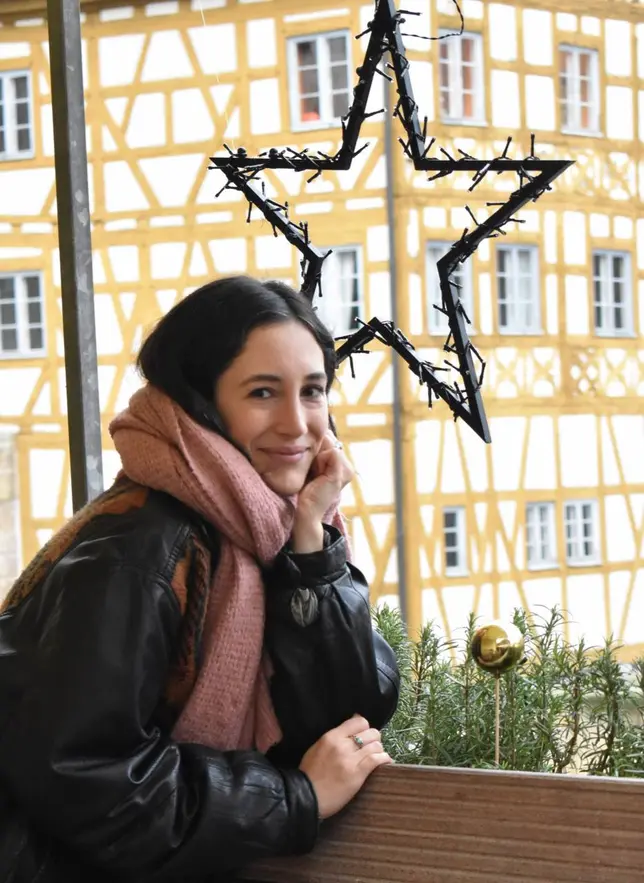 Portrait von Yildiz Asar vor dem Alten Rathaus Bamberg und Weihnachtsstern