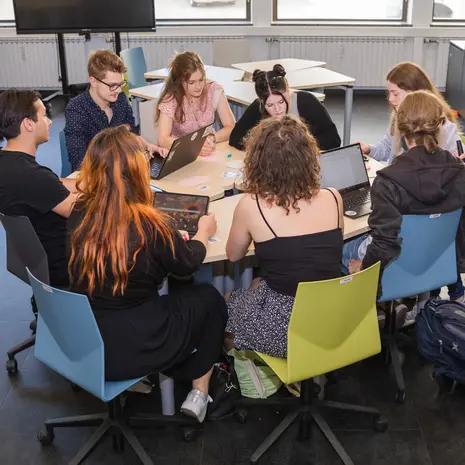 Studierende sitzen in Stuhlkreis