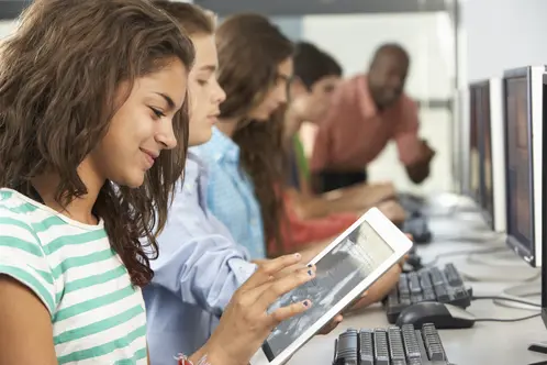 Girl Using Digital Tablet In Computer Class