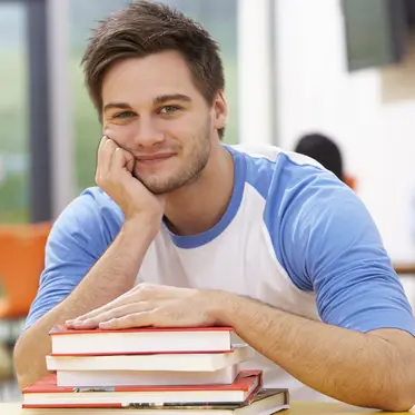 Praxisnahe Publikationen Male Student Studying In Classroom With Books