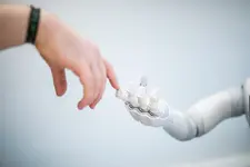 Bild Hand berührt Roboterhand mit dem Zeigefinger