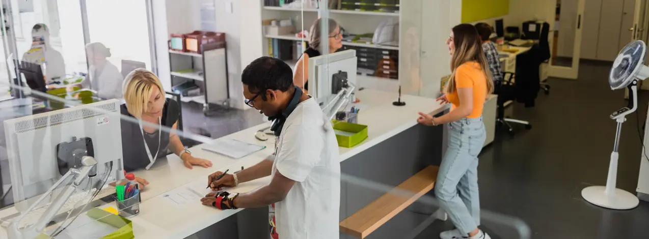 Studierende schreiben sich in der Studierendenkanzlei für einen Studiengang ein.