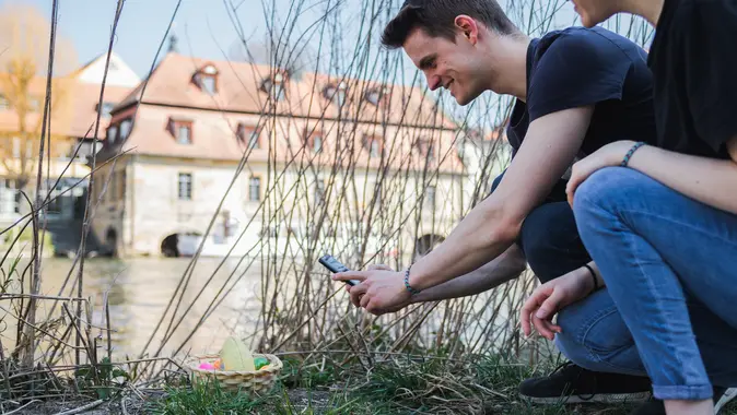Ein junger Mann findet mit der App ein Osternest.