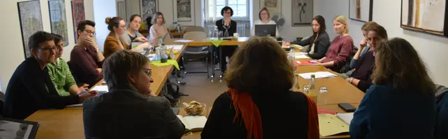 This picture shows 15 people sitting in a circle at the meeting of the Academic Equal Opportunity Advisory Board. 