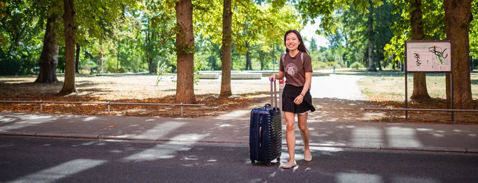 Studentin mit Koffer auf dem Weg zum ERBA-Gelände