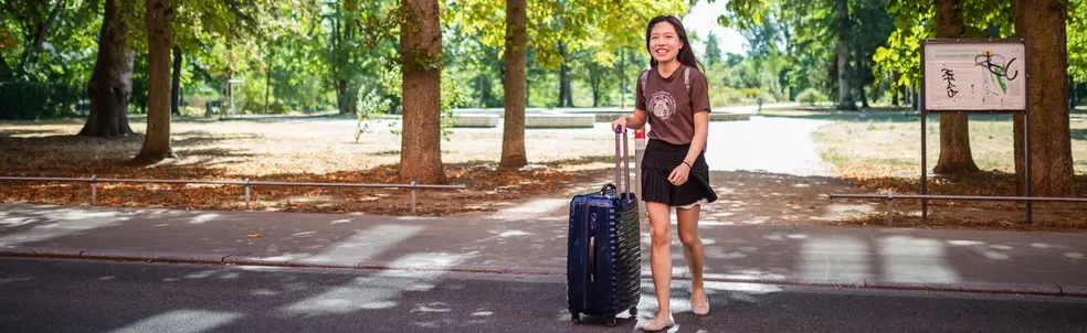auf Reisen Studentin mit Koffer auf dem Weg zum ERBA-Gelände