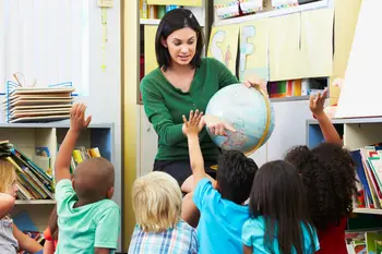 Lehrerin mit Globus und Schülern