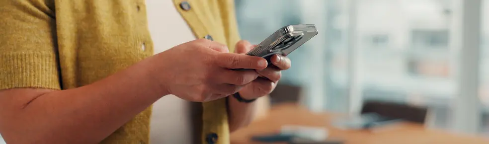 Hands, phone and texting in office at startup, contact and notification for deal at media company. Person, smartphone and scroll with mobile app, chat or social network management at creative agency