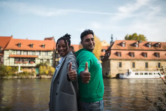 Eine junge Frau und ein junger Mann zeigen den Daumen nach oben.