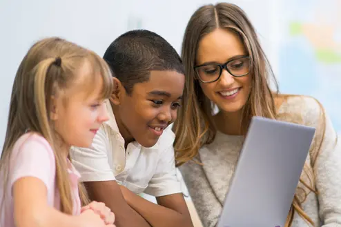 Lehrerin mit zwei Schüler*innen