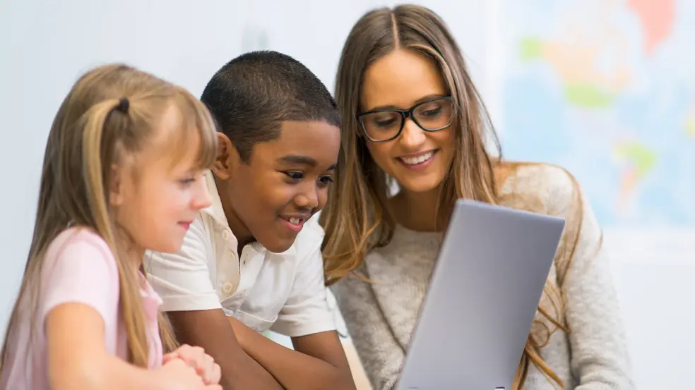 Lehrerin mit zwei Schüler*innen