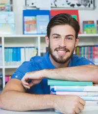 School teacher sitting with books in library Lehrer sitzt mit Büchern in der Bibliothek