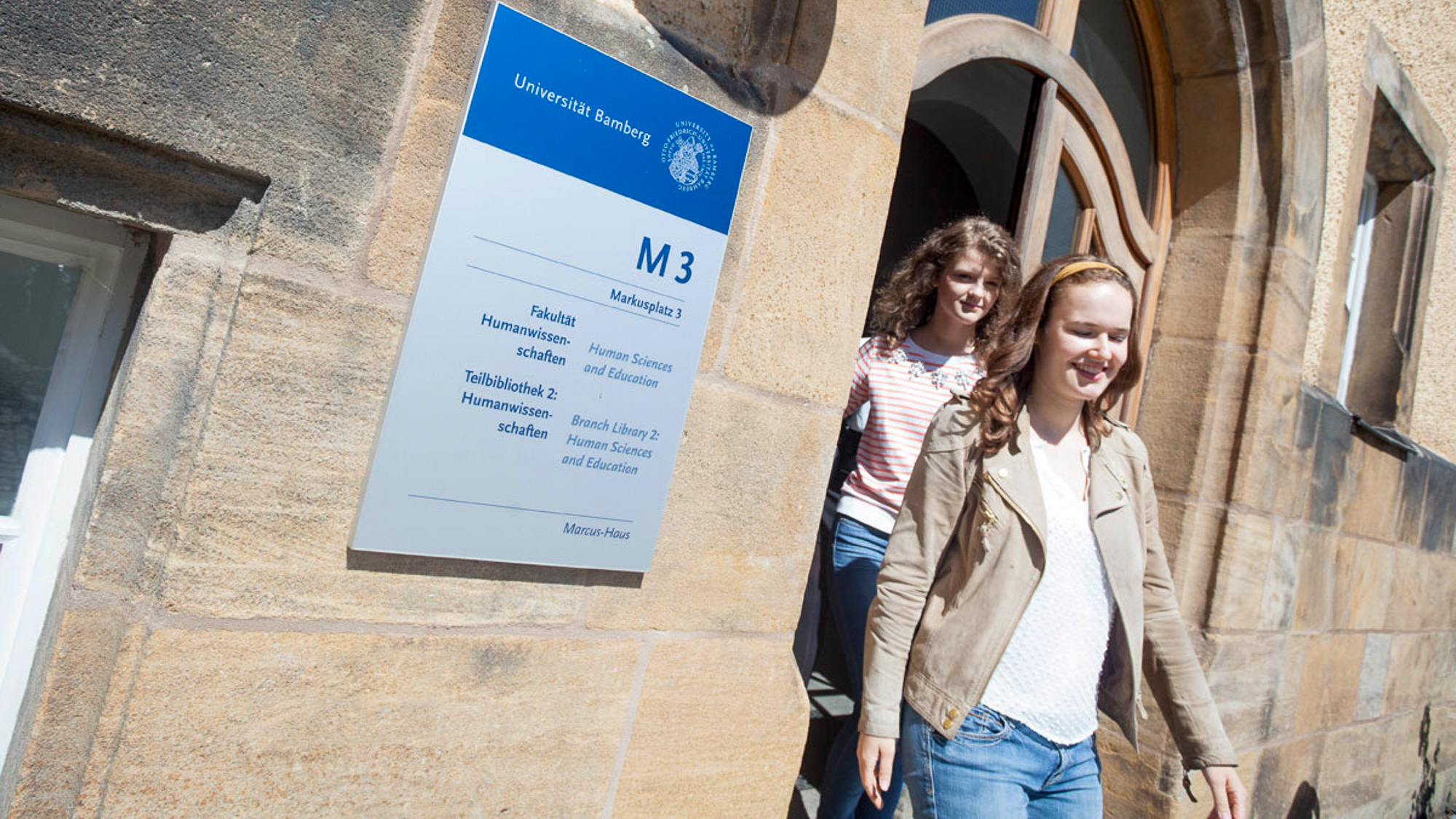 Studierende laufen aus dem M3 Gebäude am Markusplatz