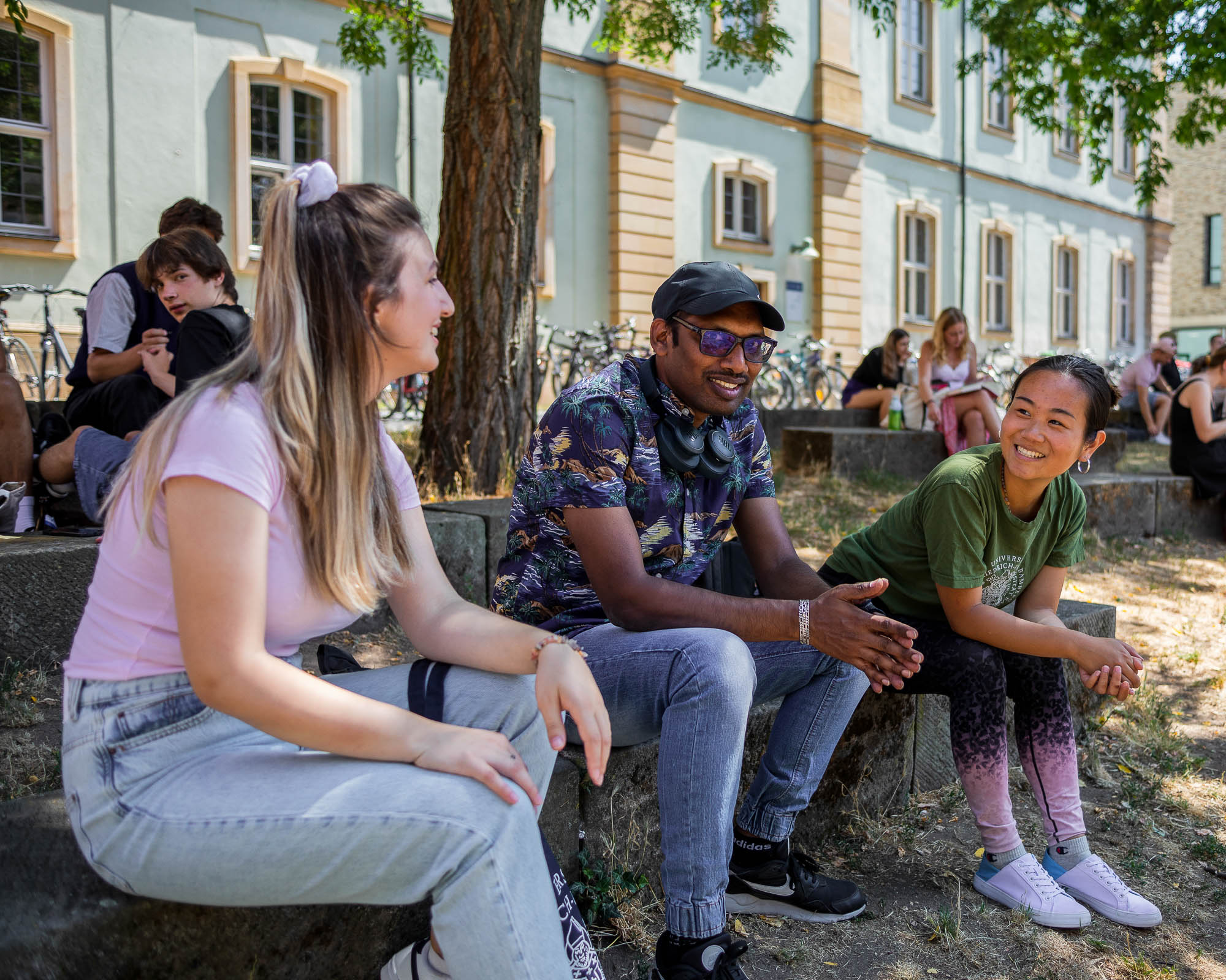 Studierende sitzen gemeinsam im Burgershof vor der TB4